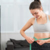 Woman measuring waistline after starting treatments to lose stubborn belly fat in Palm Harbor FL