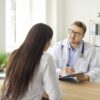 Provider taking notes during a medical weight loss evaluation consultation with a patient