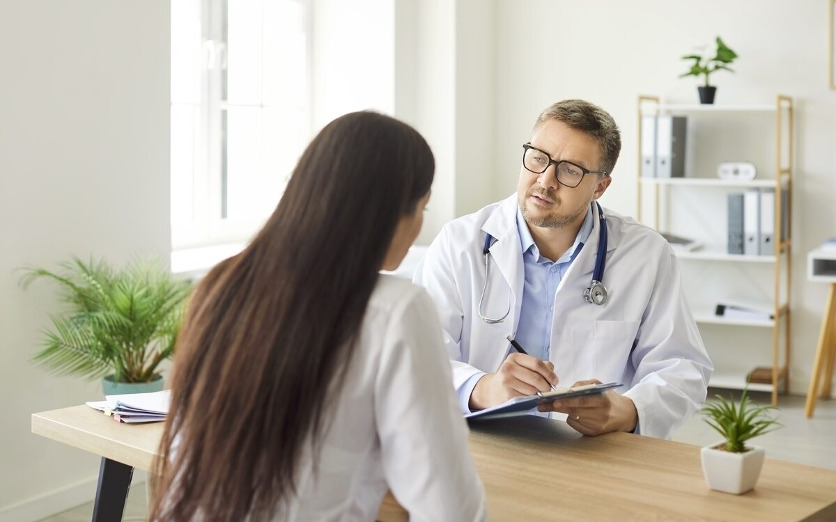 Provider taking notes during a medical weight loss evaluation consultation with a patient
