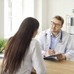 Provider taking notes during a medical weight loss evaluation consultation with a patient