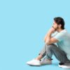 Man sitting on a scale feeling frustrated with a weight loss plateau considering medical weight loss treatments
